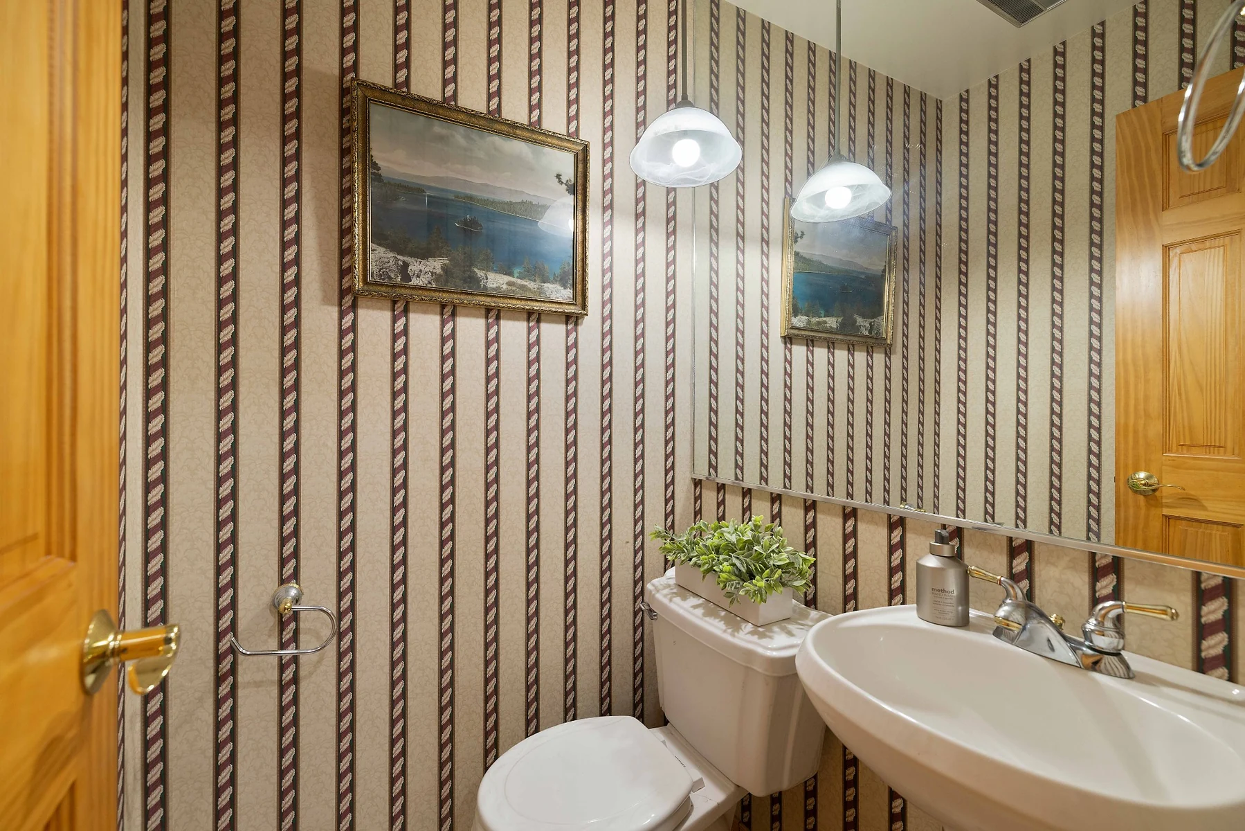Powder room with vintage wallpaper and pedestal sink