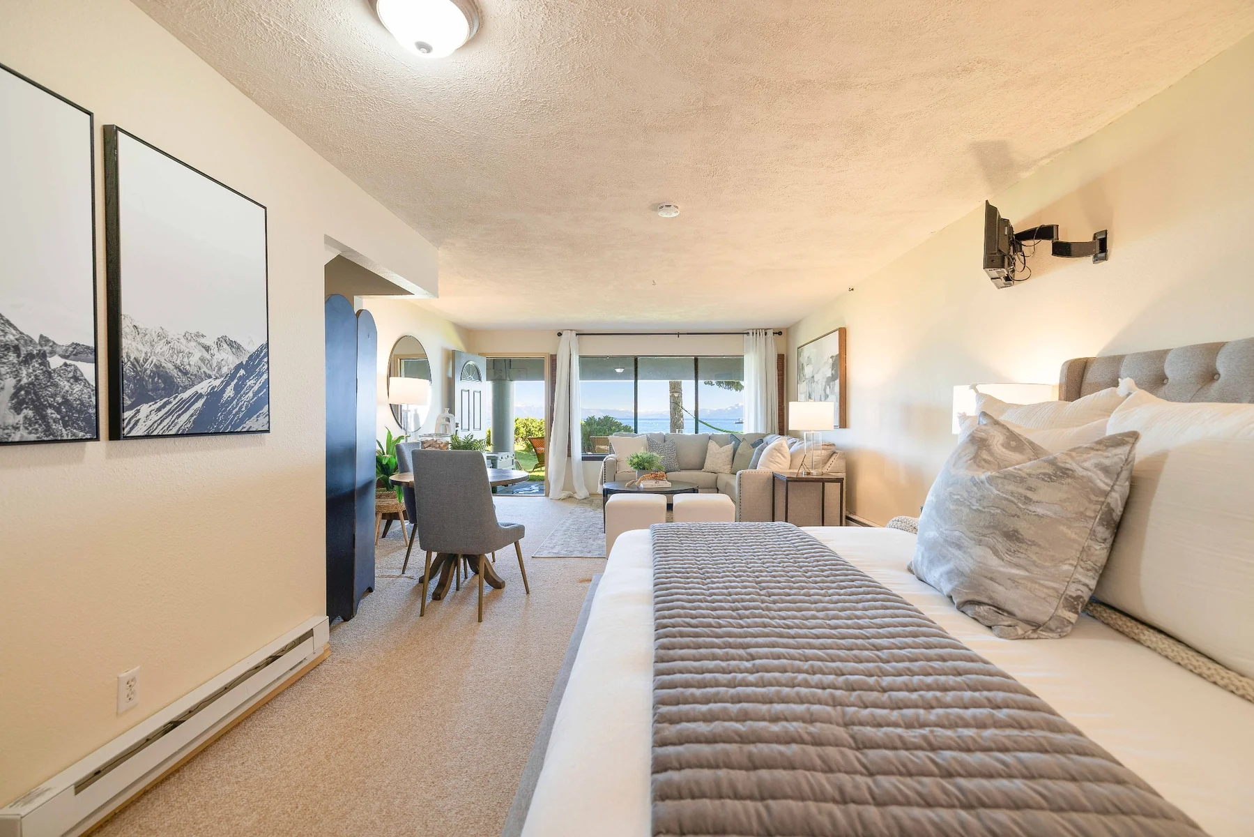 Bedroom and living area with lake views through sliding doors