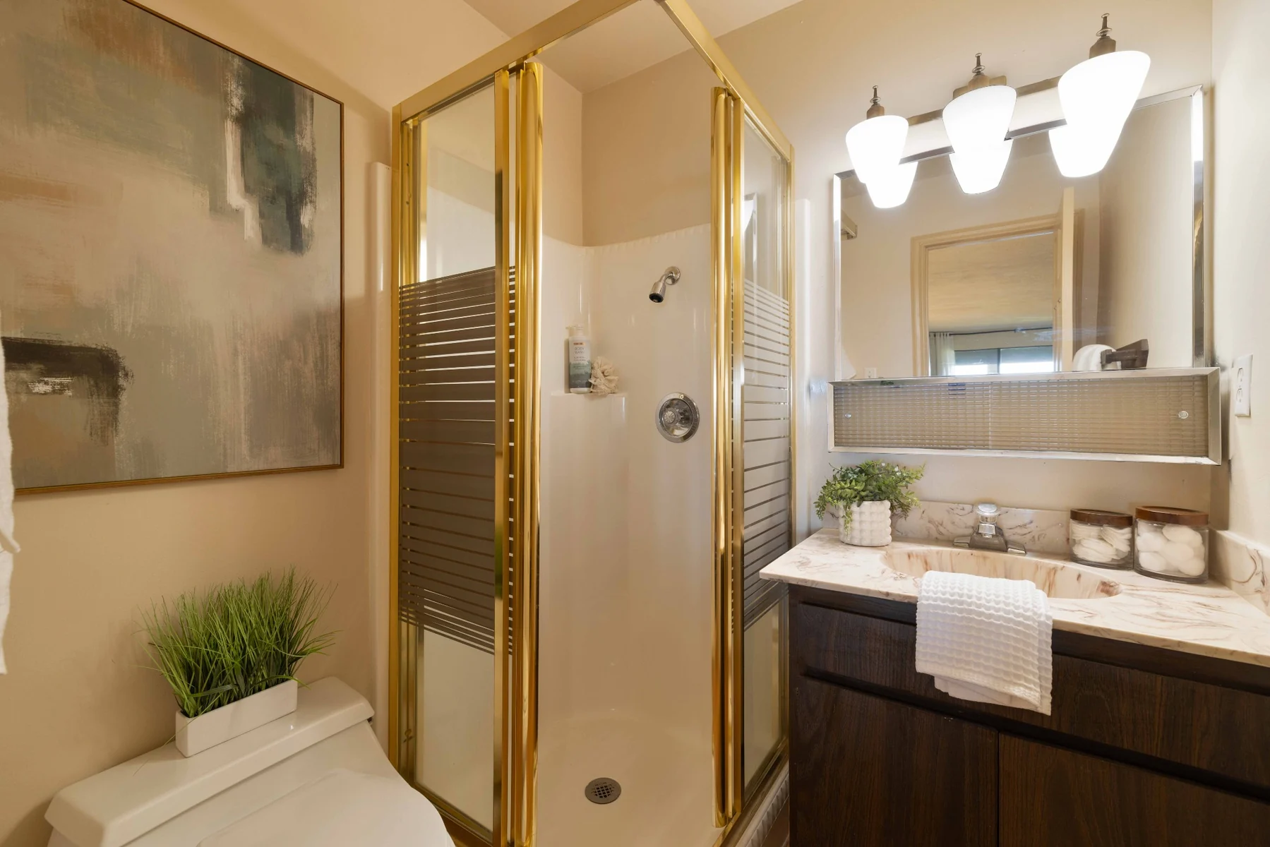 Guest bathroom with gold-framed shower and vanity